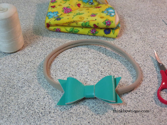 Attach leatherette bow to nylon headband